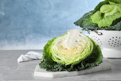 Photo of Half of fresh green savoy cabbage on table against light blue background. Space for text