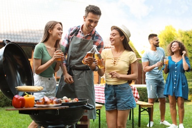 Photo of Group of friends having fun at barbecue party outdoors