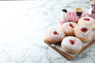 Delicious jam donuts served with coffee on white marble table. Space for text