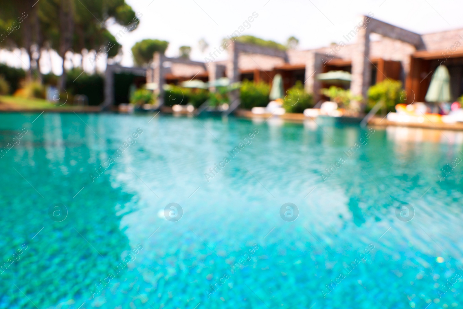 Photo of Luxury resort with outdoor swimming pool and sun loungers on sunny day, blurred view