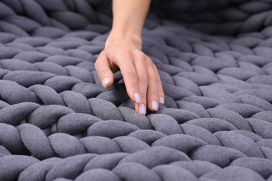 Photo of Woman touching grey chunky knit plaid, closeup