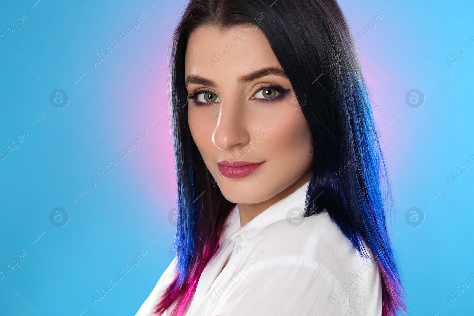 Photo of Young woman with bright dyed hair on color background