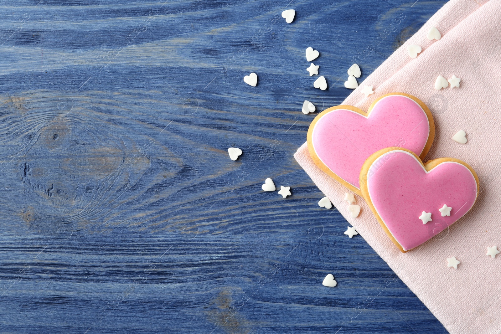 Photo of Flat lay composition with decorated heart shaped cookies and space for text on wooden background