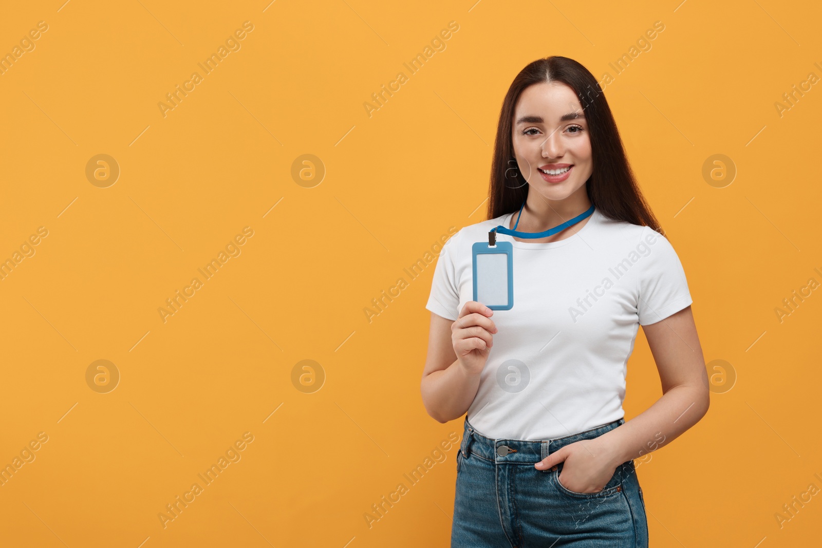 Photo of Happy woman with vip pass badge on orange background. Space for text