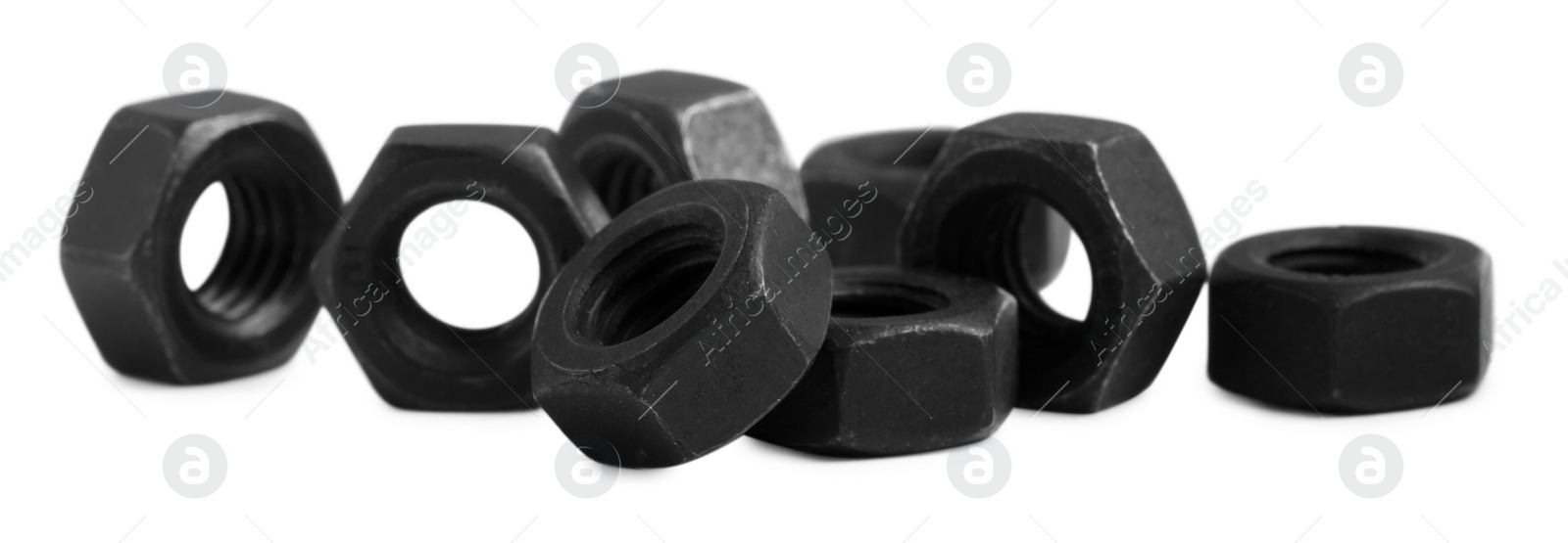 Photo of Many black metal hex nuts on white background