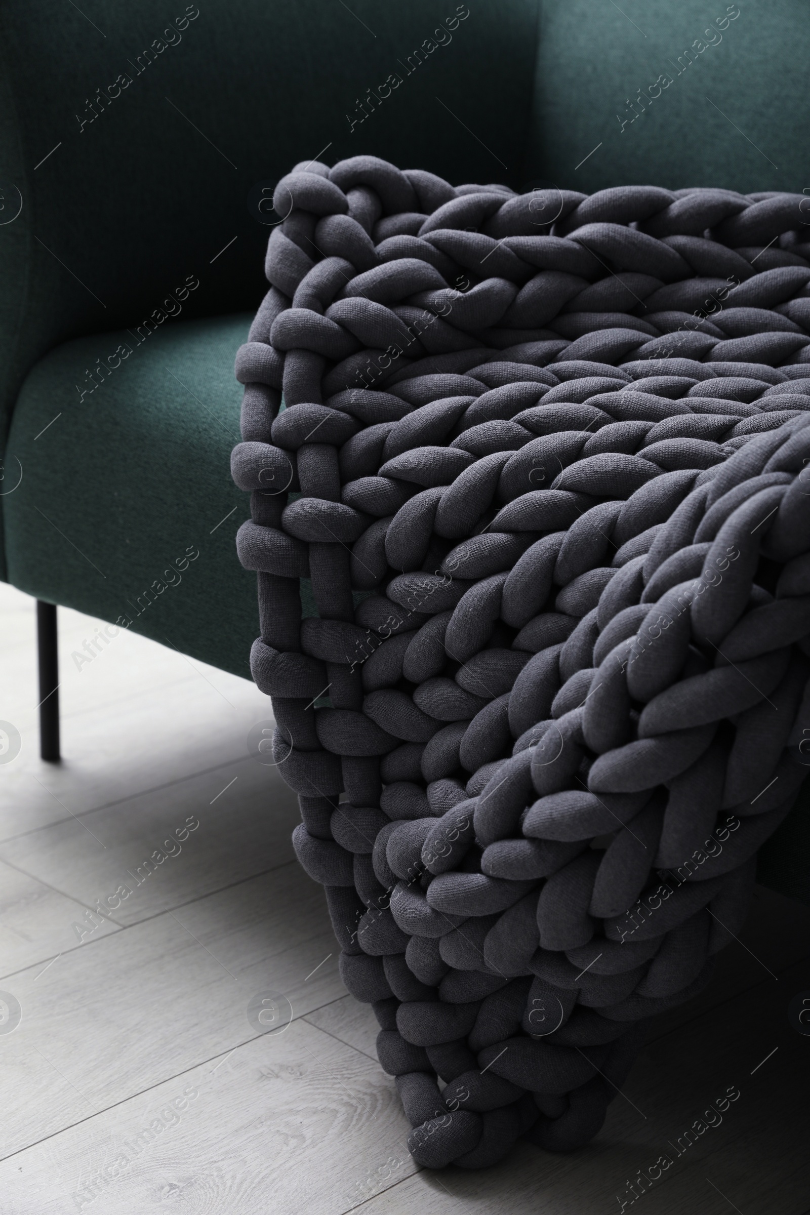 Photo of Soft chunky knit blanket on sofa indoors, closeup