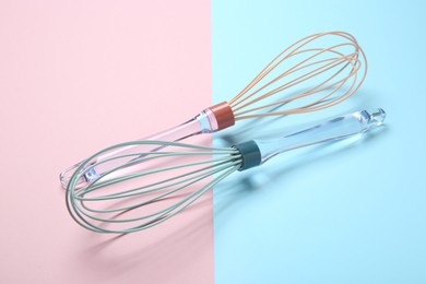 Photo of Two whisks on color background. Kitchen utensils