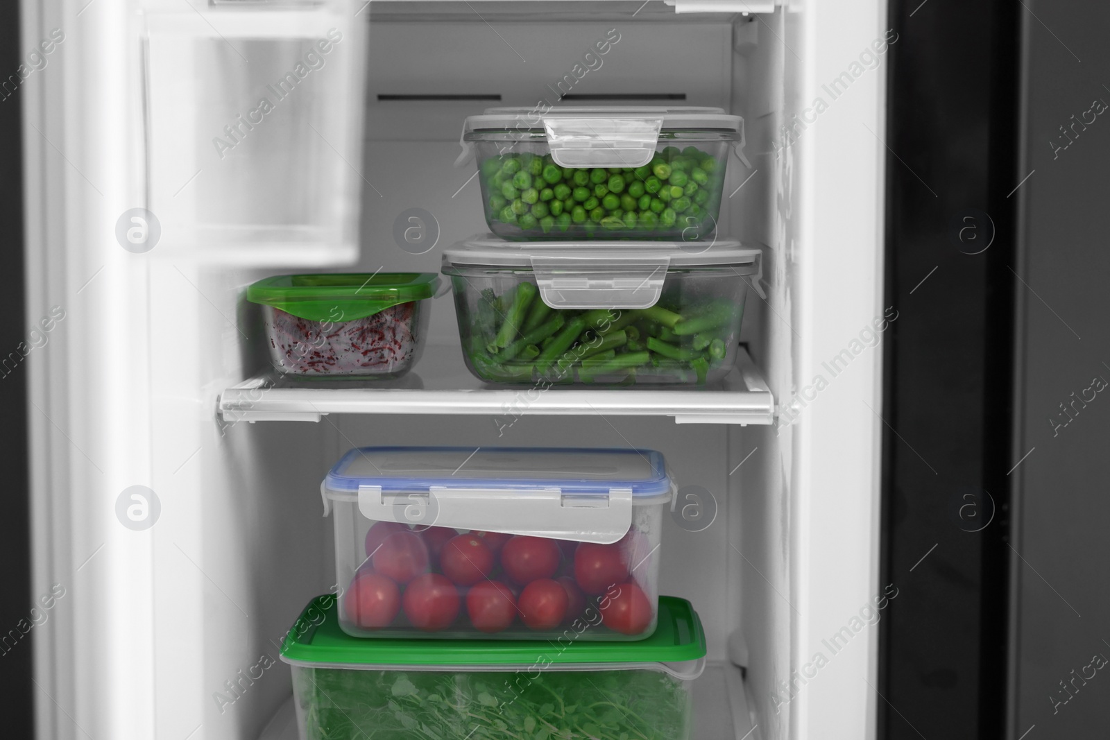Photo of Glass and plastic containers with different fresh products in fridge. Food storage