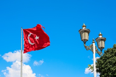 Photo of Turkish flag fluttering on blue sky background