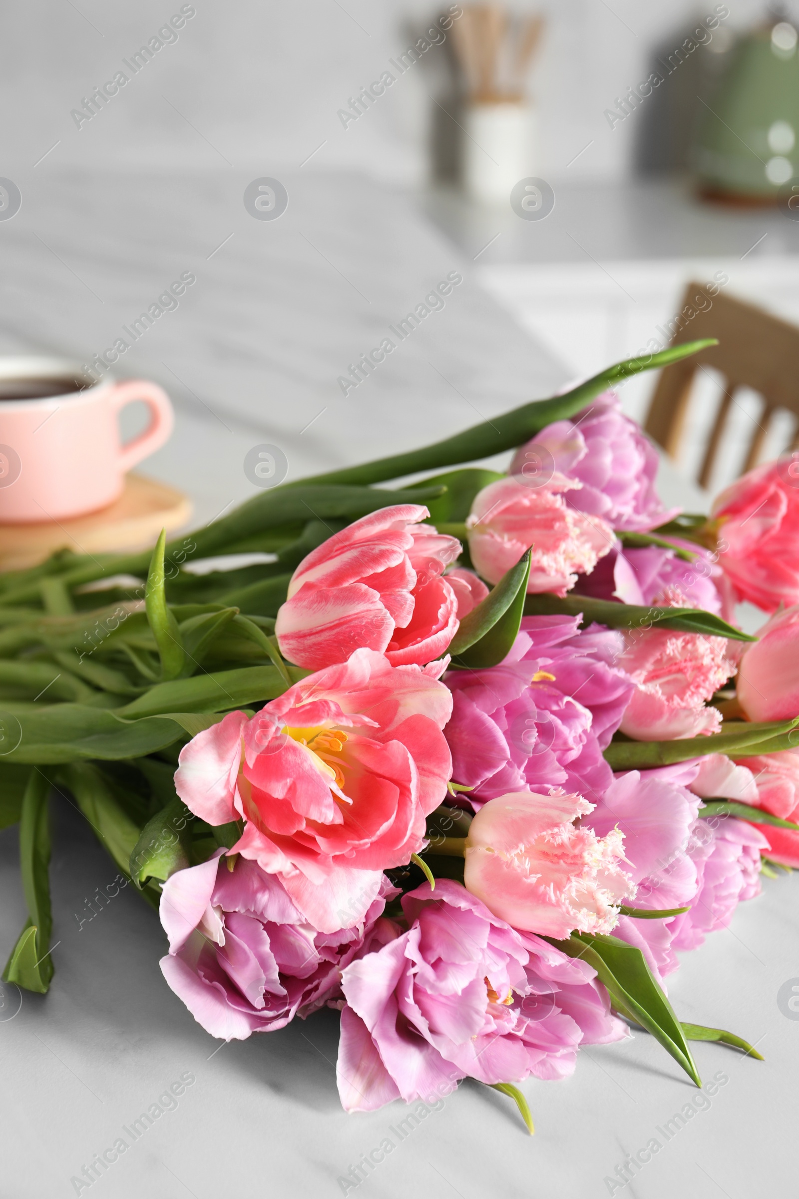 Photo of Beautiful bouquet of colorful tulip flowers on white table indoors