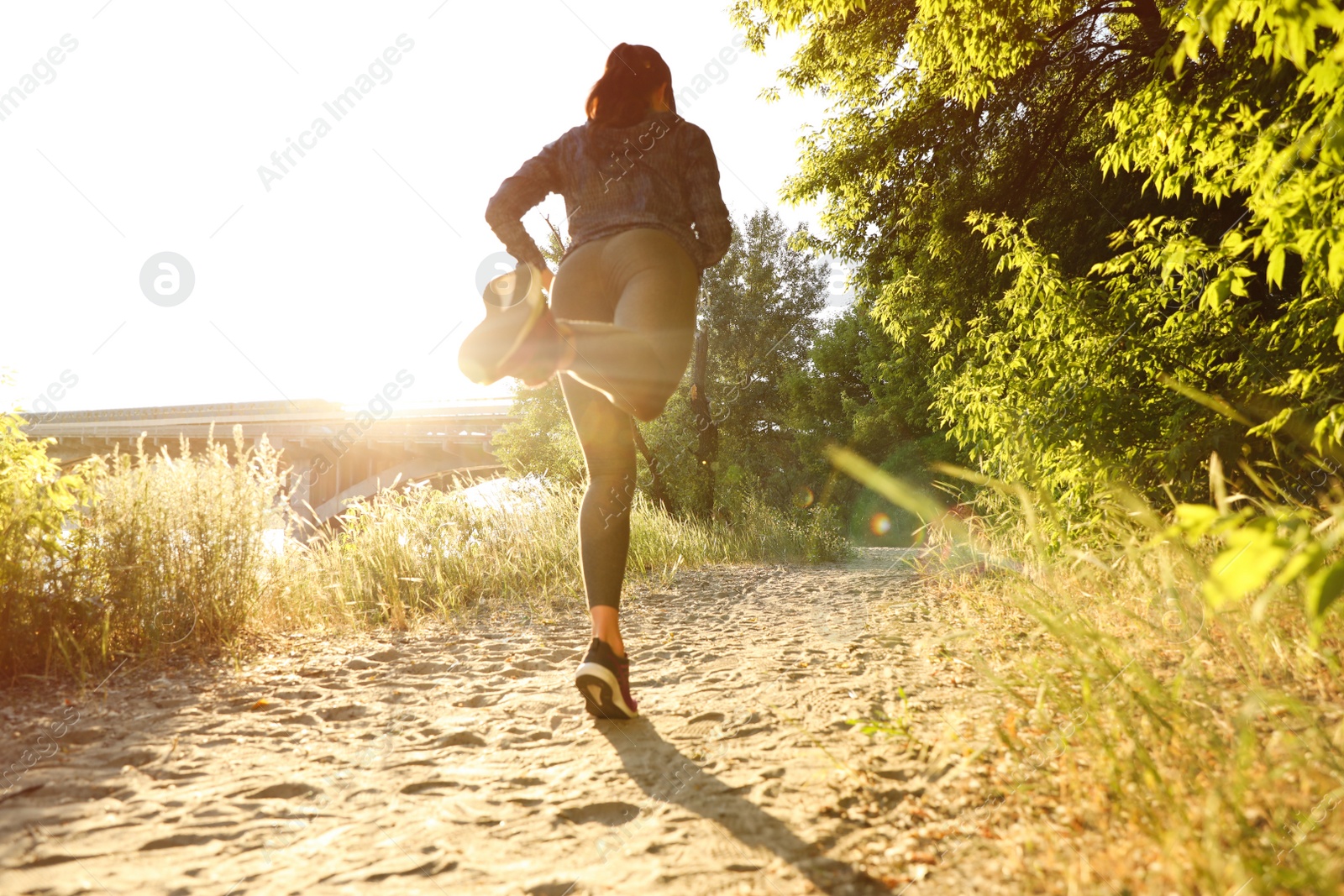 Photo of Young woman running in park on sunny day