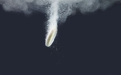 Photo of Effervescent pill dissolving in water on dark background, closeup