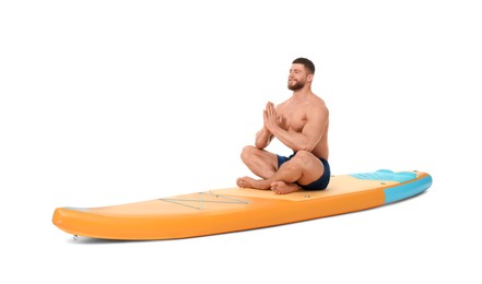 Happy man practicing yoga on orange SUP board against white background