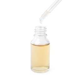 Photo of Dripping essential oil from pipette into glass bottle on white background