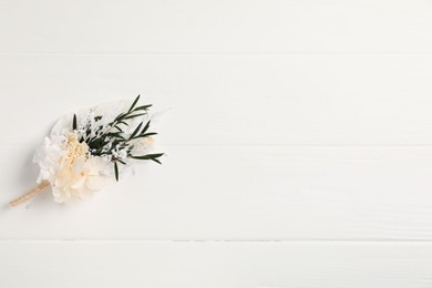 Photo of Beautiful boutonniere on white background, top view. Space for text