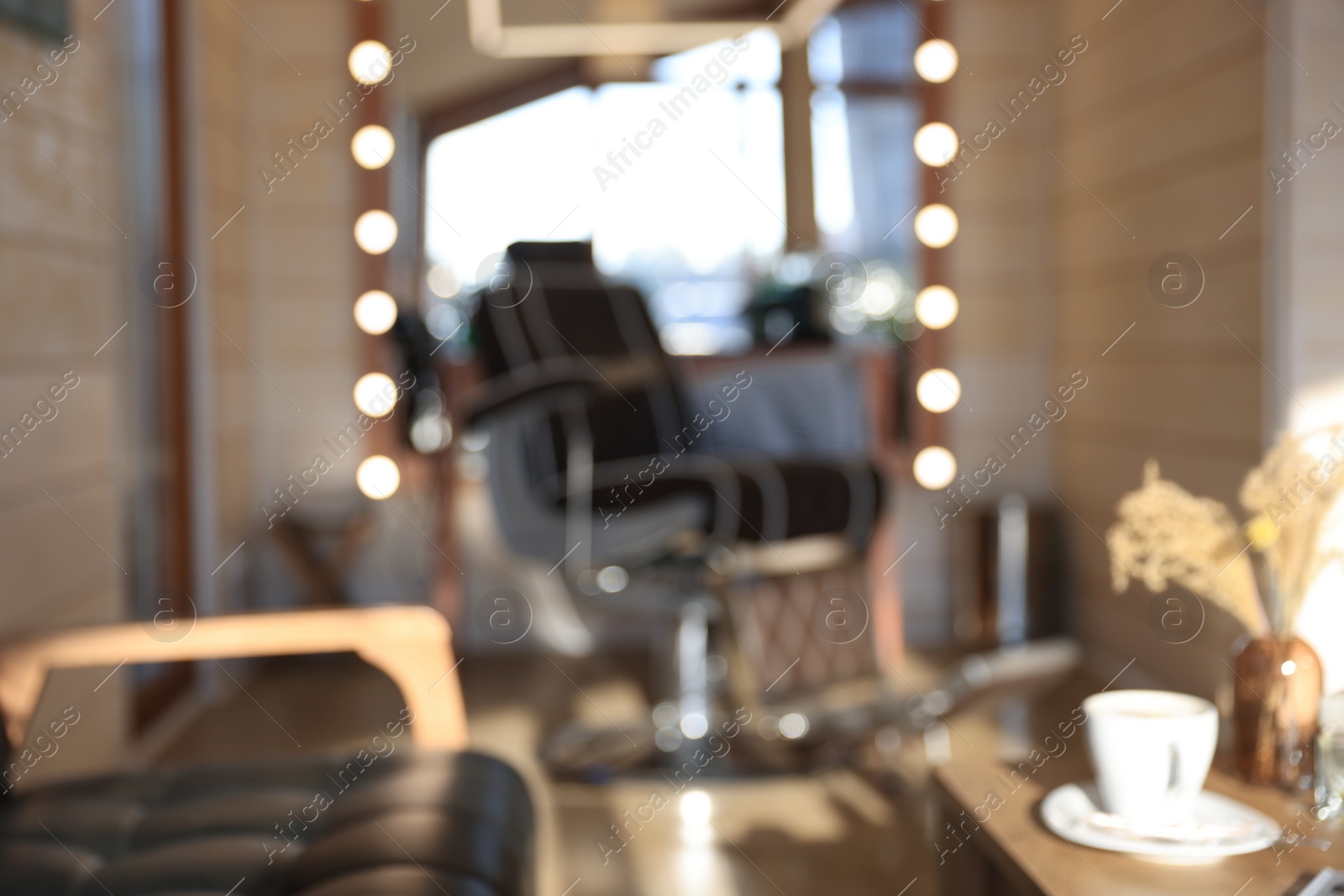 Photo of Blurred view of stylish barbershop interior with hairdresser workplace