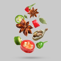 Image of Different spices falling on light grey background