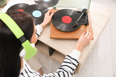 Photo of Woman listening to music with turntable at home, above view