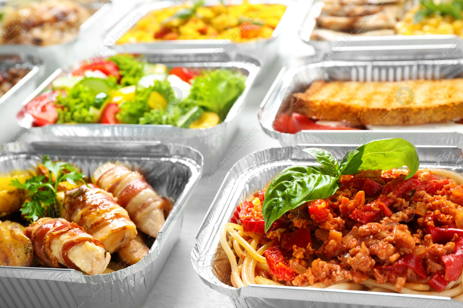 Photo of Lunchboxes on white wooden table, closeup. Healthy food delivery