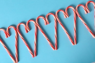 Photo of Sweet hearts made of candy canes on color background, top view