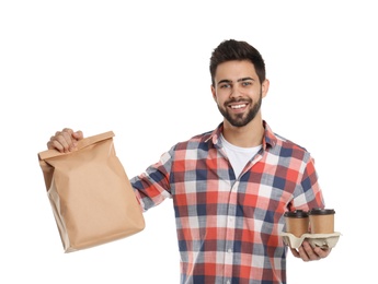 Young courier with paper bag and drinks on white background. Food delivery service