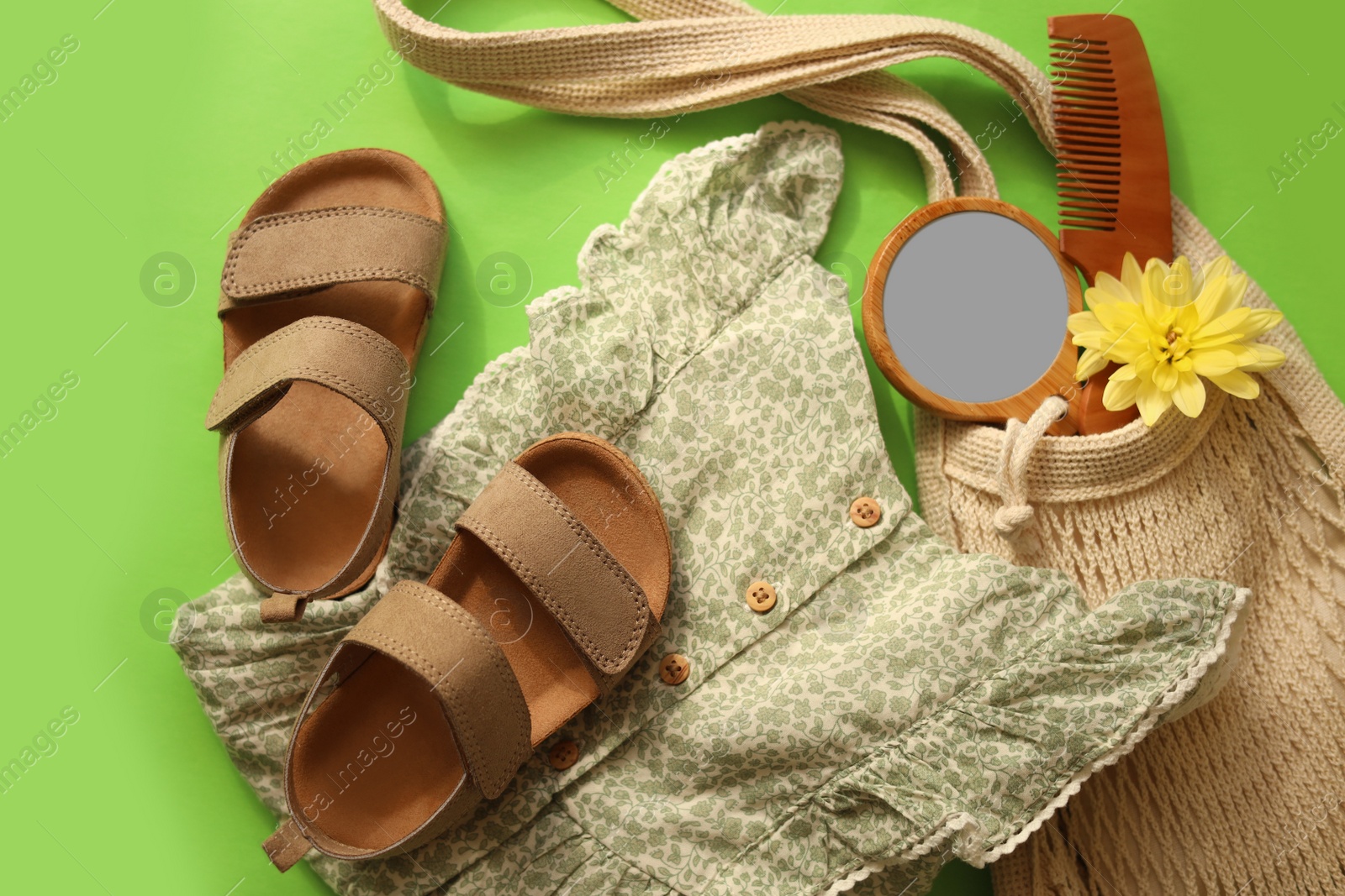 Photo of Stylish child clothes, shoes and accessories on green background, flat lay