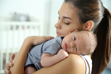 Photo of Young woman with her newborn baby at home