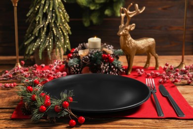 Festive place setting with beautiful dishware, cutlery and decor for Christmas dinner on wooden table