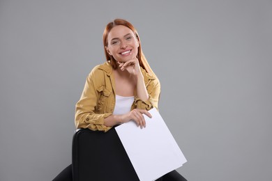 Casting call. Young woman with script on chair against grey background, space for text