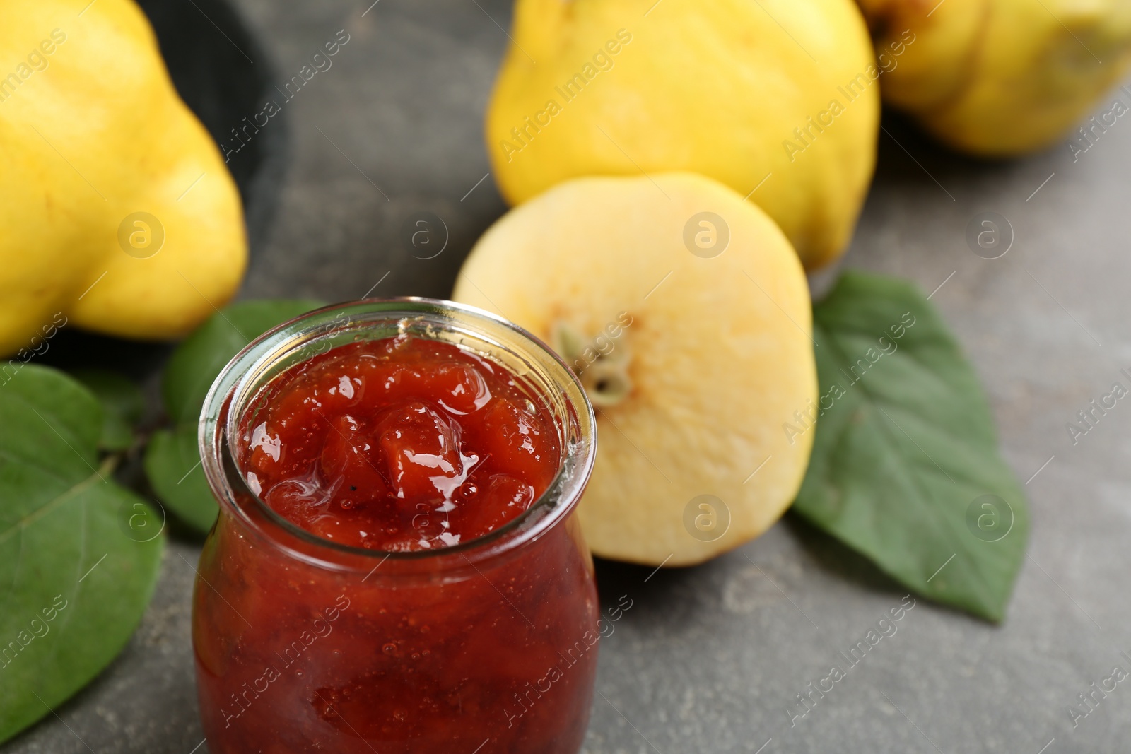 Photo of Delicious quince jam on grey table, closeup