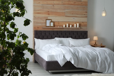 Photo of Large comfortable bed in stylish room. Modern interior design