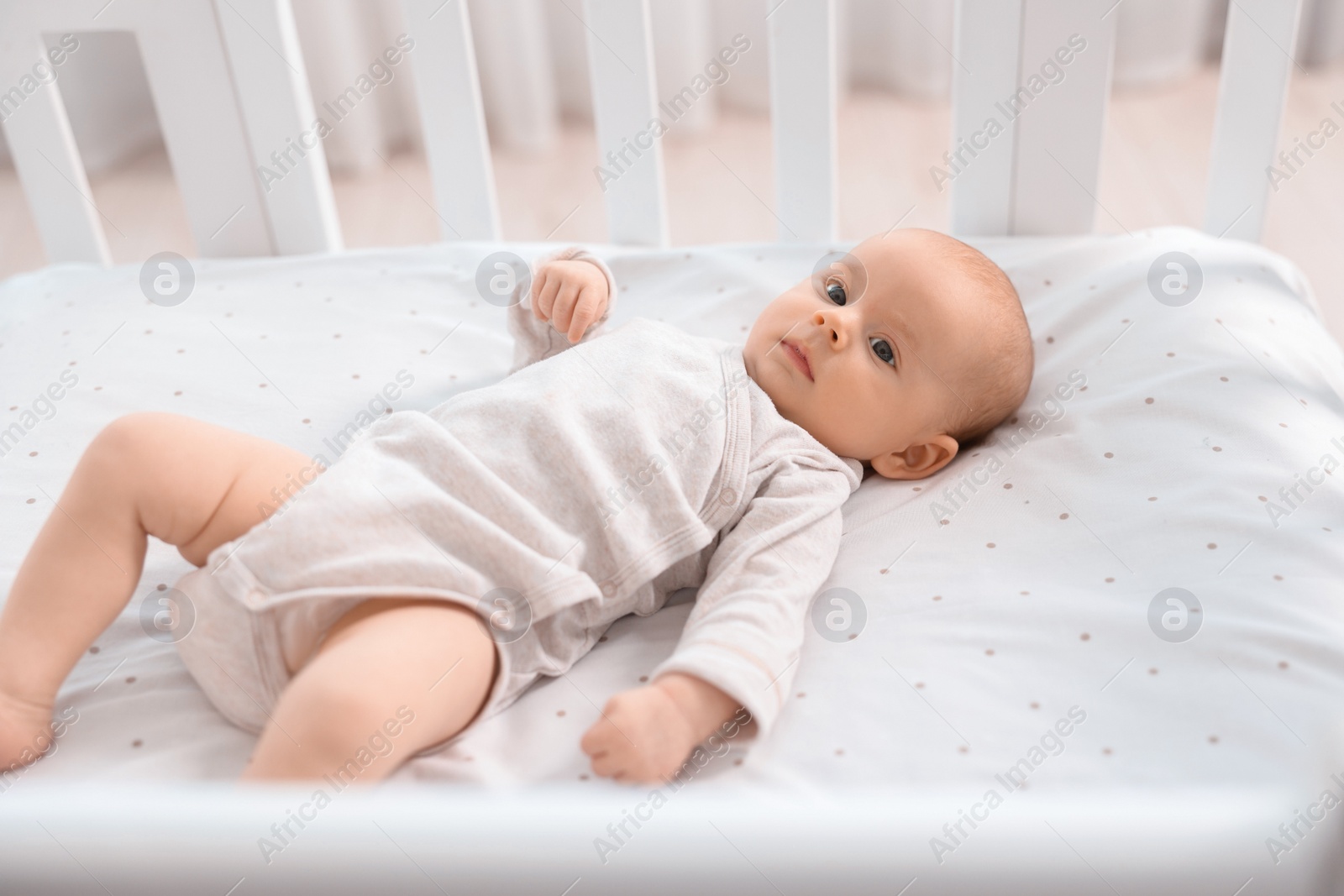 Photo of Cute little baby lying in crib at home