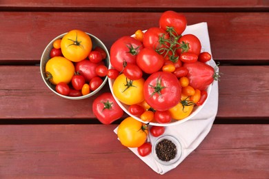 Bowls with fresh tomatoes and spices on wooden table, flat lay
