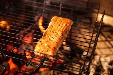 Photo of Grilling basket with salmon fillet in oven, closeup