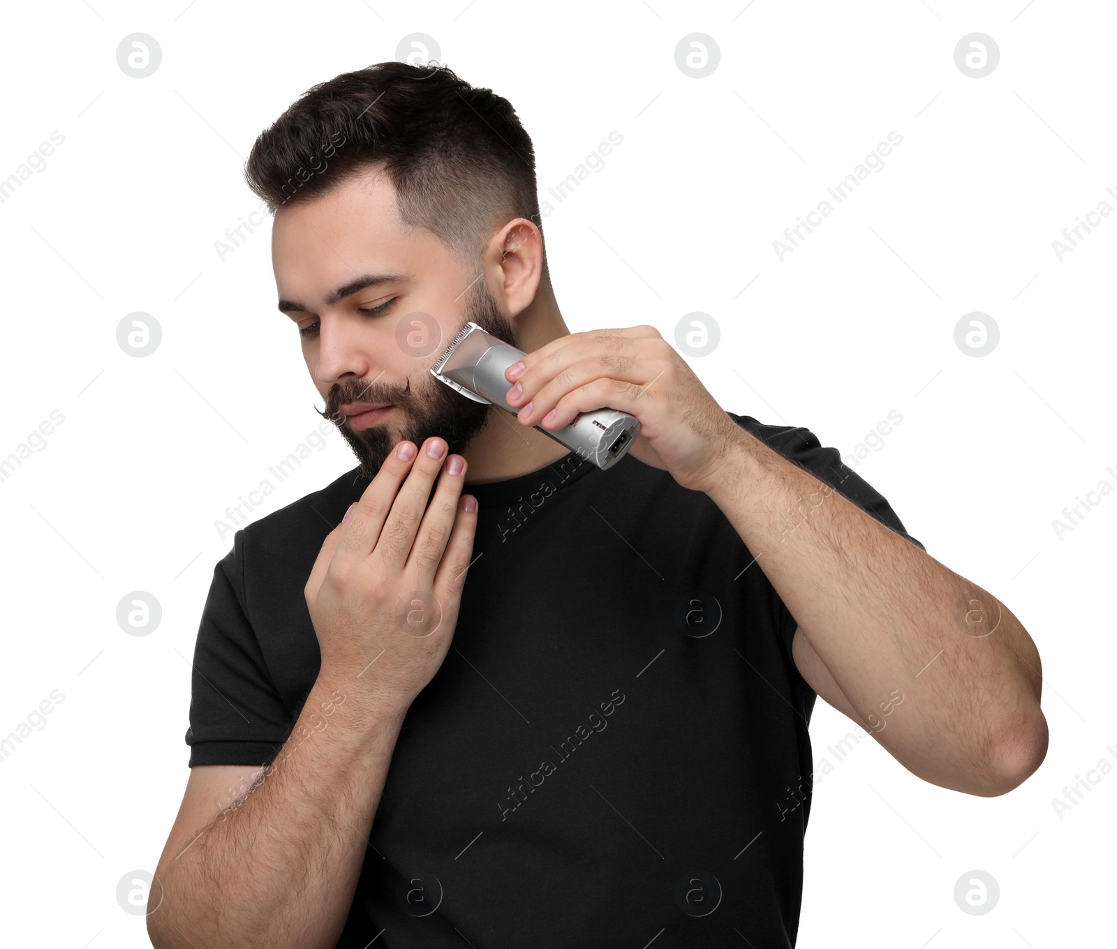 Photo of Handsome young man trimming beard on white background