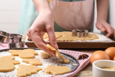 Photo of Woman making Christmas cookies at wooden table, closeup