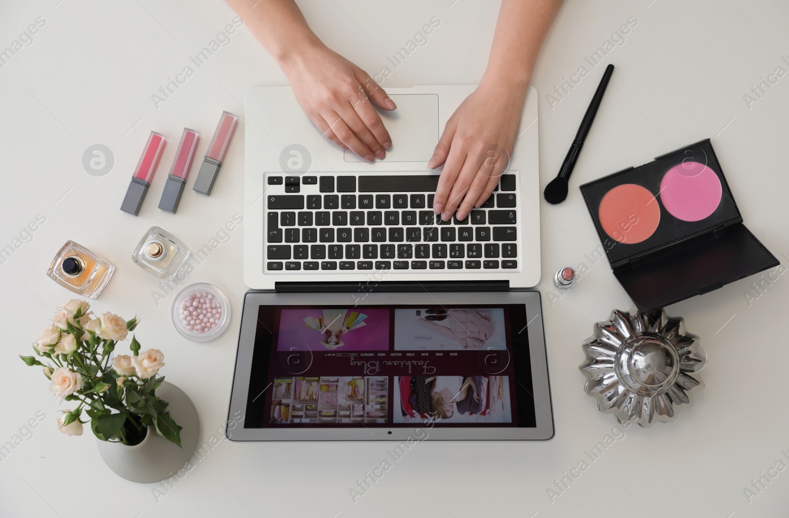 Photo of Woman working with fashion blogger site on laptop at table, top view