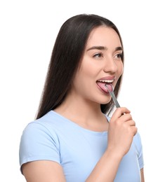 Photo of Happy woman brushing her tongue with cleaner on white background