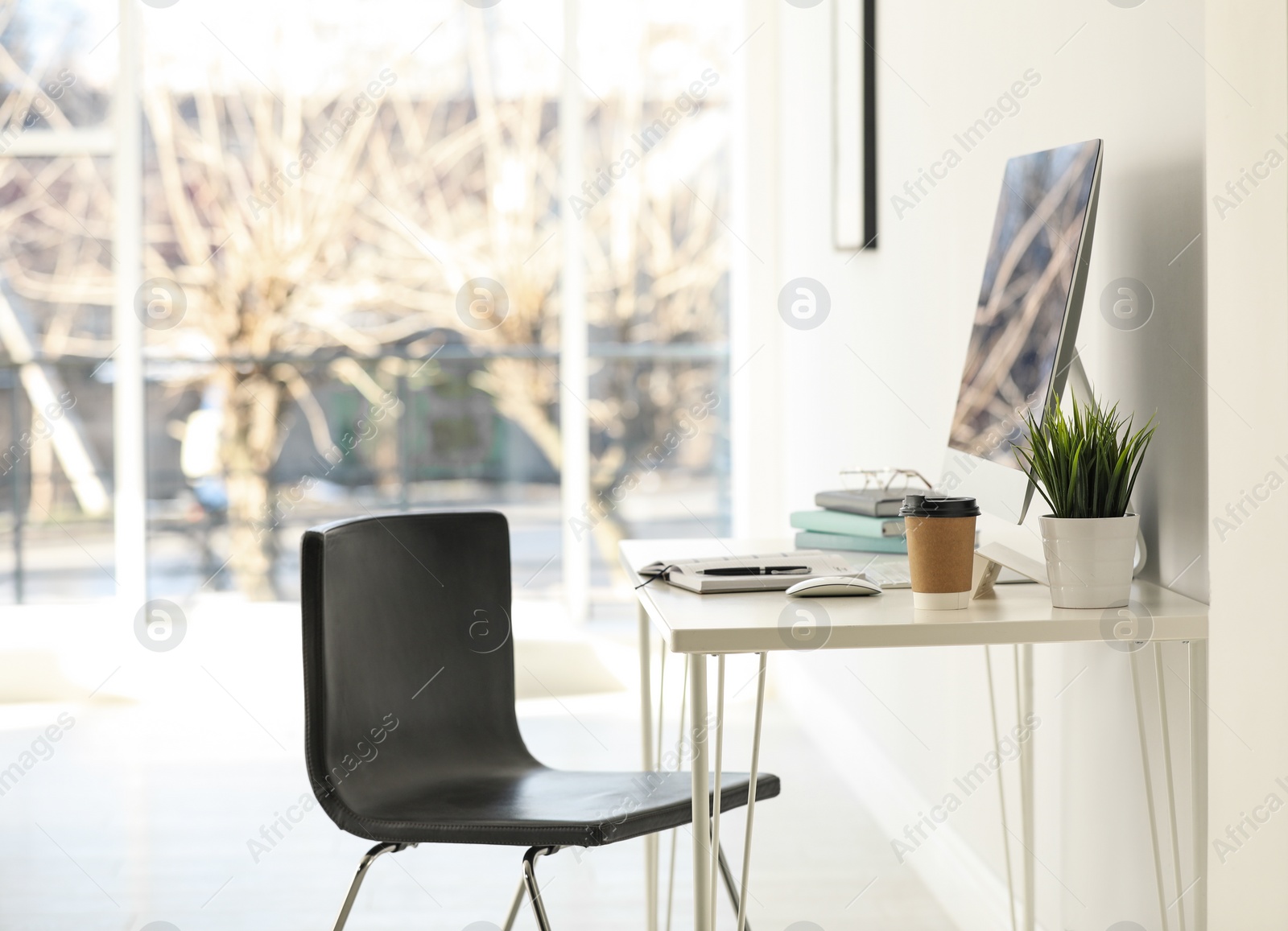 Photo of Computer, notebooks and coffee on table in office