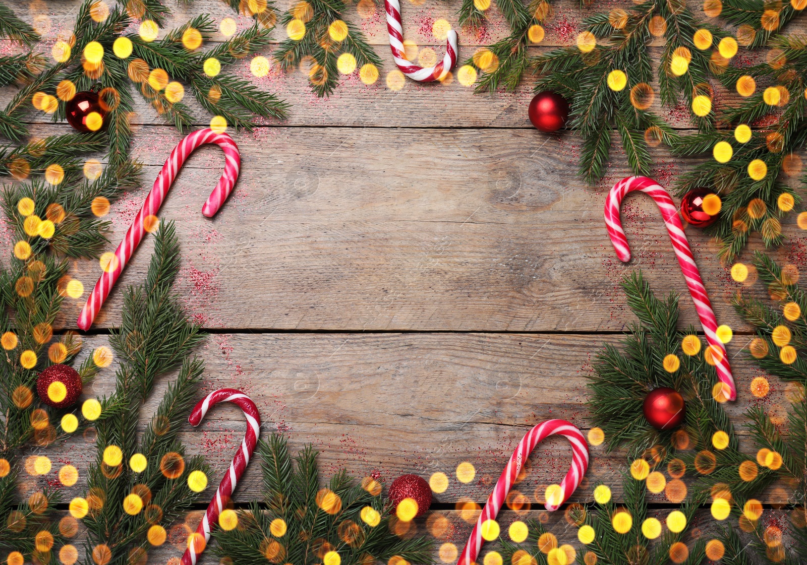 Photo of Christmas greeting card with space for text. Flat lay composition of fir tree branches and festive decor on wooden background