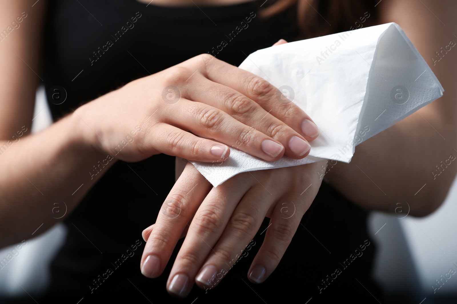 Photo of Woman cleaning hands with paper napkin, closeup