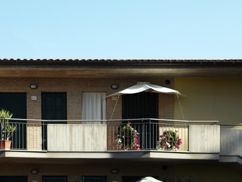 Photo of Exterior of building with flowers on balcony