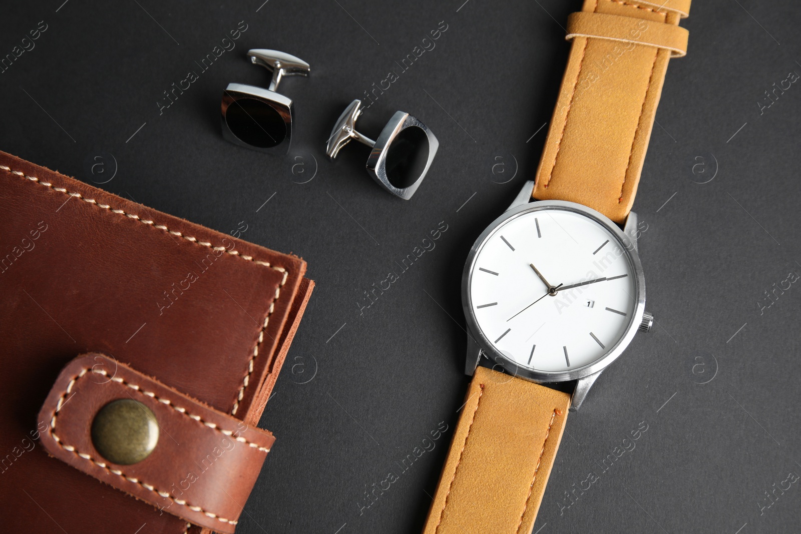 Photo of Stylish wrist watch, cuff links and wallet on black background. Fashion accessory