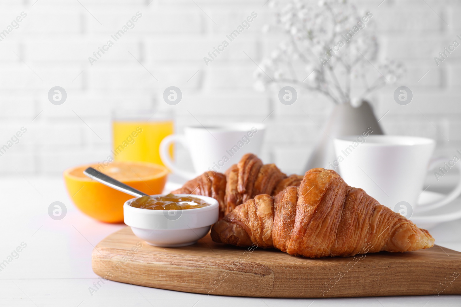 Photo of Croissants and jam on white wooden table. Tasty breakfast