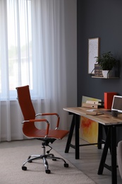 Modern workplace with comfortable chair in stylish home office interior