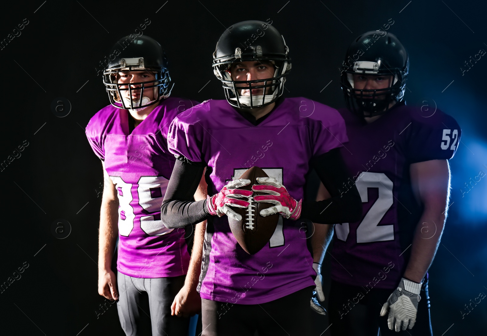 Photo of American football players in uniform on dark background