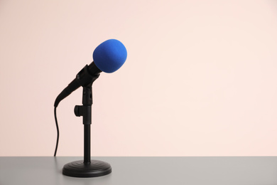 Photo of Microphone on light grey table, space for text. Journalist's work
