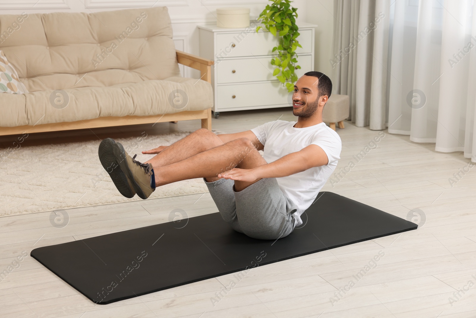 Photo of Man doing morning exercise on fitness mat at home