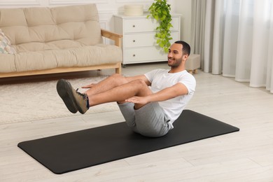 Photo of Man doing morning exercise on fitness mat at home