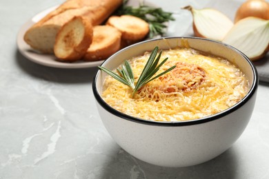 Photo of Tasty homemade french onion soup served on grey marble table